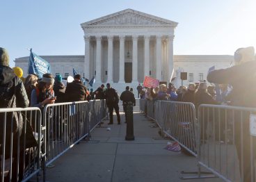 Supreme Court Police officers guard a barrier between anti-abortion and pro-abortion rights protesters outside the court building.